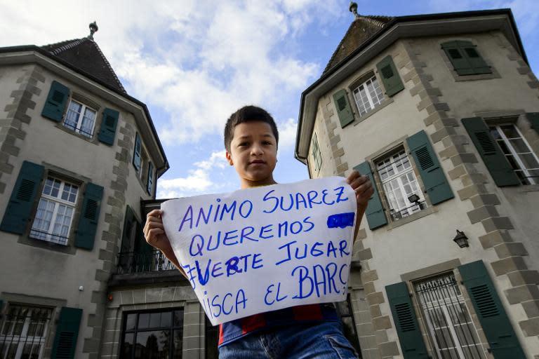 Ten-year-old Carlo poses with a placard reading "Come on! Suarez, we want to see you playing at Barca" in front of the Court of Arbitration for Sport (CAS) on August 8, 2014 in Lausanne