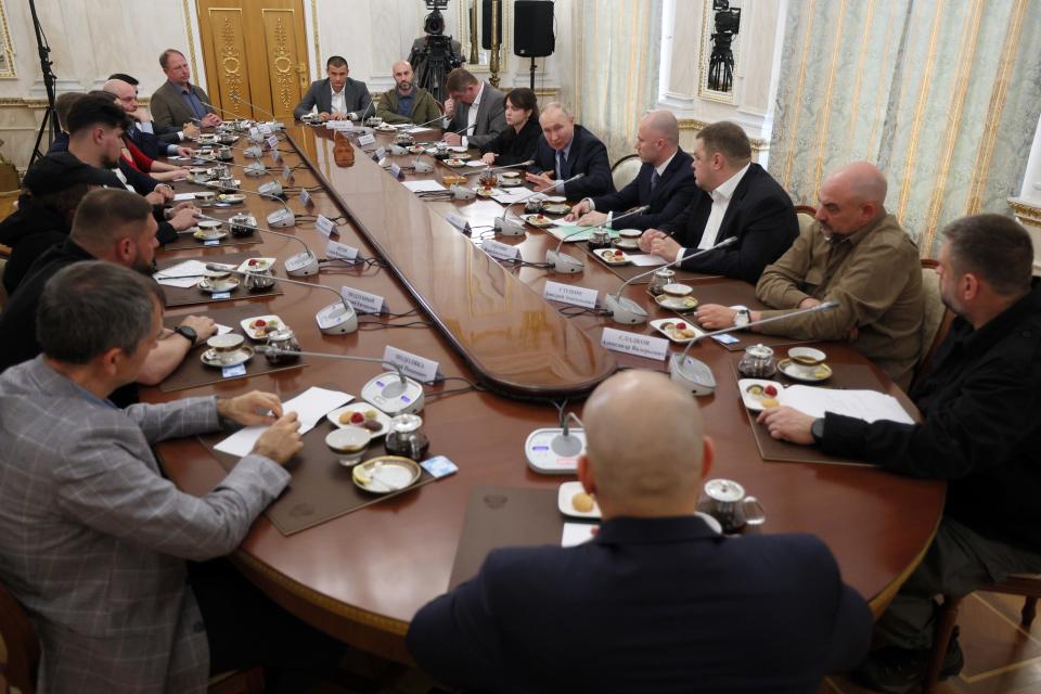 Russian President Vladimir Putin, fifth from right, speaks during a meeting with Russian war correspondents who cover a special military operation at the Kremlin in Moscow, Russia, Tuesday, June 13, 2023. (Gavriil Grigorov, Sputnik, Kremlin Pool Photo via AP)