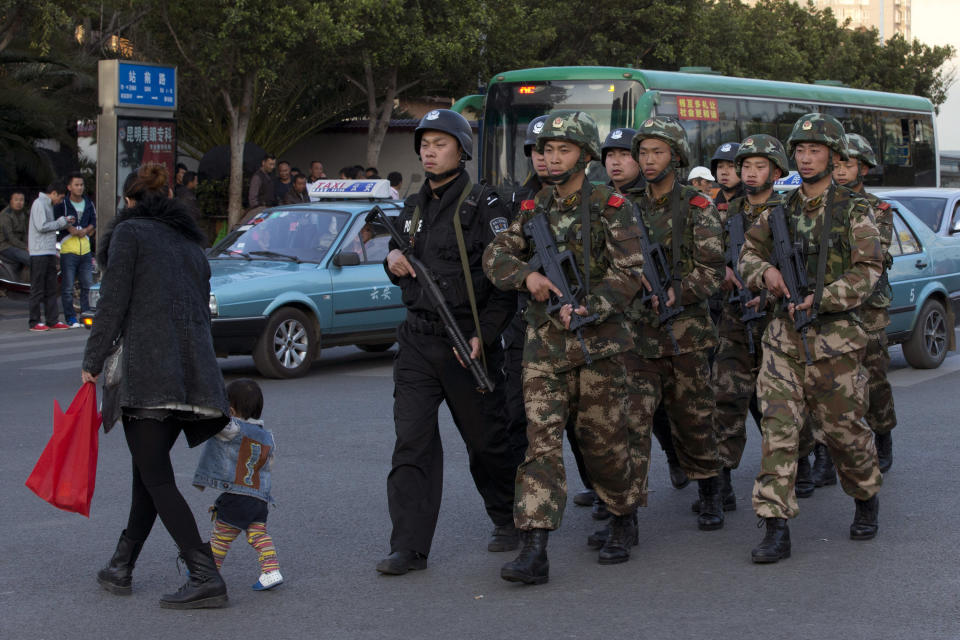 Armed policemen and paramilitary policemen patrol a street near the Kunming Railway Station, where more than 10 assailants slashed scores of people with knives Saturday evening, in Kunming, in southwestern China's Yunnan province, Monday, March 3, 2014. Twenty-nine slash victims and four attackers were killed and 143 people wounded in the attack which officials said was a terrorist assault by ethnic separatists from the far west. (AP Photo/Alexander F. Yuan)