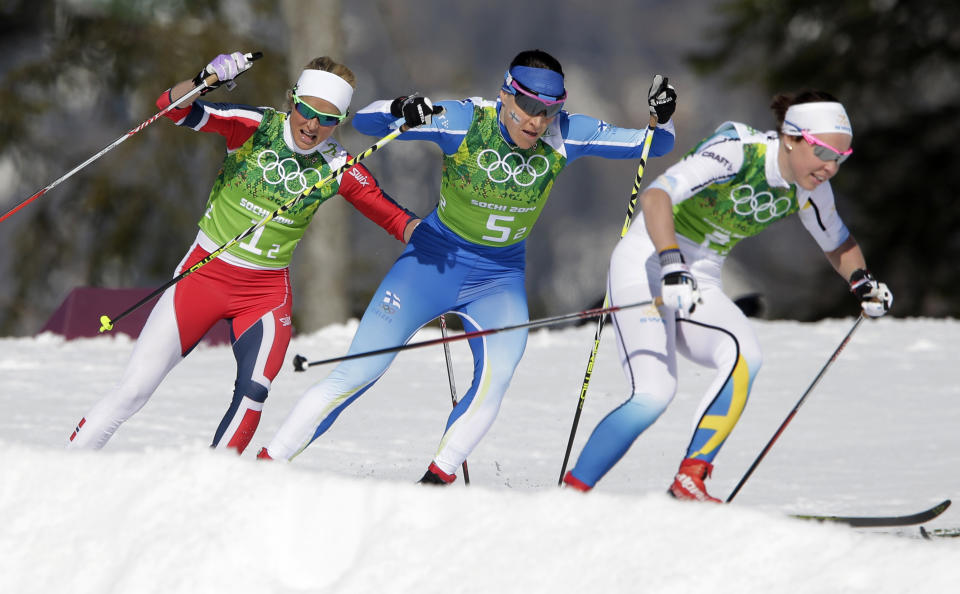 Norway's Therese Johaug, Finland's Aino-Kaisa Saarinen, and Sweden's Emma Wiken, from left, take a curve during the women's 4x5K cross-country relay at the 2014 Winter Olympics, Saturday, Feb. 15, 2014, in Krasnaya Polyana, Russia. (AP Photo/Matthias Schrader)