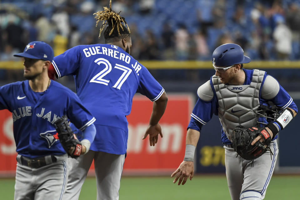 Toronto Blue Jays' Vladimir Guerrero Jr. (27) and Danny Jansen celebrate a win over the Tampa Bay Rays during a baseball game Sunday, July 11, 2021, in St. Petersburg, Fla.(AP Photo/Steve Nesius)