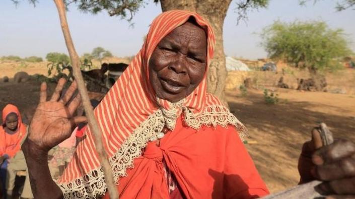 Deifa Adam Yussuf, a Sudanese refugee who fled violence in Sudan's Darfur region, reacts as she stands in her makeshift shelter under a tree, near the Sudan-Chad border in Koufroun, Chad , May 9, 2022