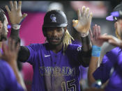 Colorado Rockies' Raimel Tapia is congratulated after scoring during the seventh inning of the team's baseball game against the Los Angeles Angels on Wednesday, July 28, 2021, in Anaheim, Calif. (AP Photo/John McCoy)