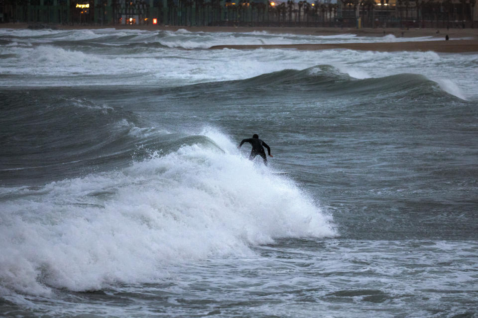 A man surfs the Mediterranean sea during strong winds in Barcelona, Spain, Sunday, Jan. 19, 2020. (AP Photo/Emilio Morenatti)