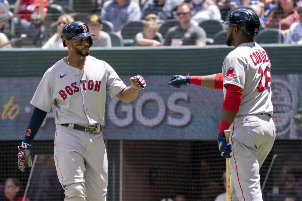Boston Red Sox's Xander Bogaerts, left, is congratulated by Franchy Cordero (16) after scoring on a groundout by Hunter Renfroe during the first inning of a baseball game against the Texas Rangers Sunday, May 2, 2021, in Arlington, Texas. (AP Photo/Jeffrey McWhorter)