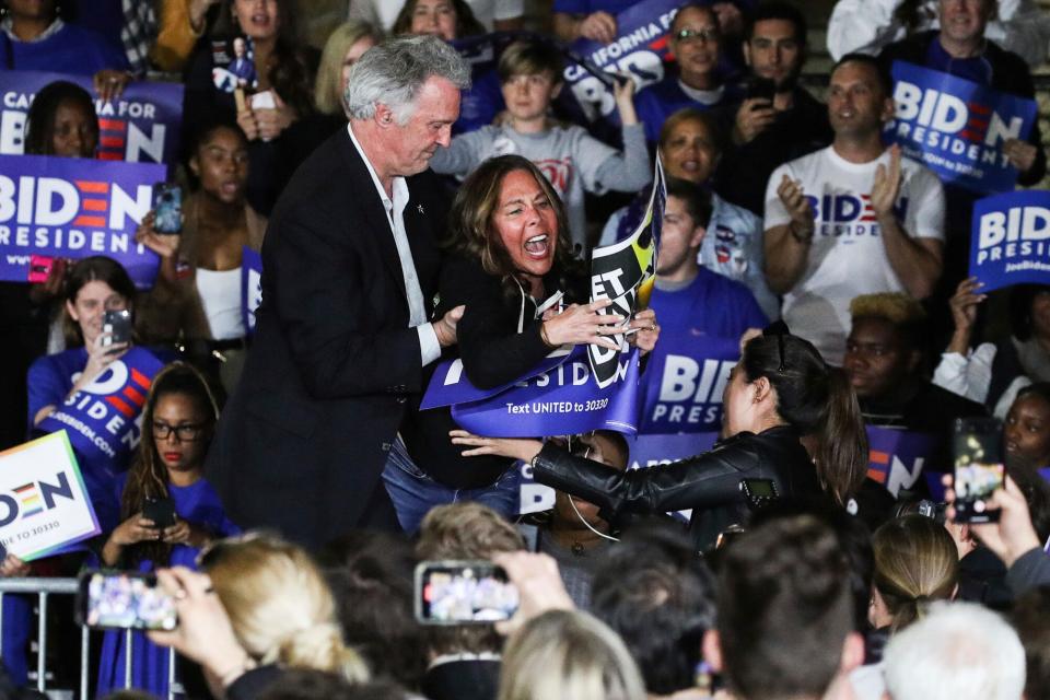 Former Vice President Joe Biden, 2020 Democratic presidential candidate, out of frame, watches as his wife Jill Biden, out of frame, and a staff member, left, block a protester holding a sign that reads 'Let Dairy Die,' right, from arriving on stage during the Jill and Joe Biden 2020 Super Tuesday Los Angeles Rally held at the Baldwin Hills Recreation Center on March 3, 2020 in Baldwin Hills, Los Angeles, California, United States.