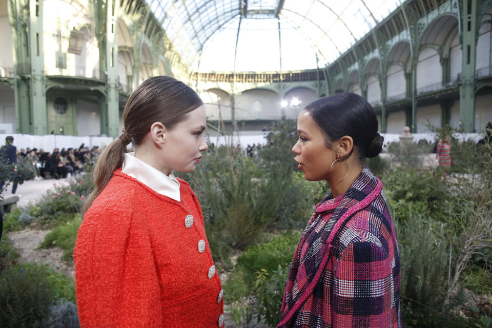 Actress Kristine Froseth, left, talks with Canadian actress Taylor Russell before Chanel Haute Couture Spring/Summer 2020 fashion collection, Tuesday Jan.21, 2020 in Paris. (AP Photo/Thibault Camus)