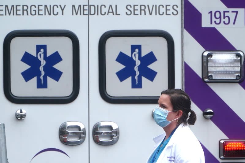 Un profesional de la salud pasa junto a una ambulancia en el distrito de Manhattan, Nueva York
