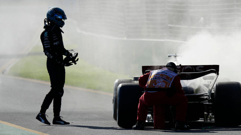 F1 driver George Russell looks on at his smoking car, which forced him to exit the 2023 Australian Grand Prix.