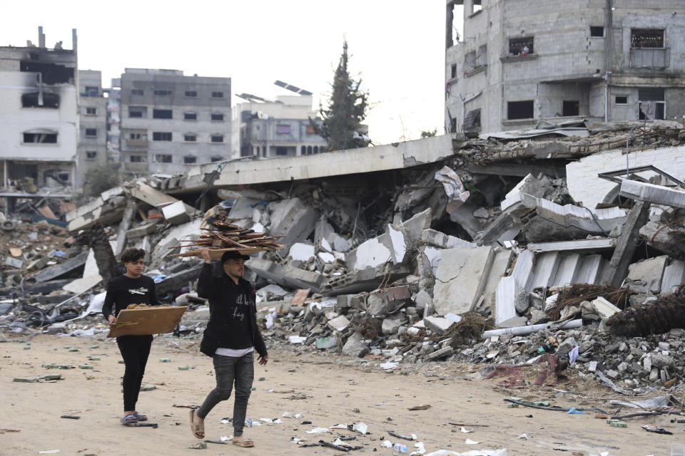 Palestinians walk past the building destroyed in the Israeli Bombardment of the Gaza Strip in Gaza City on Wednesday, Jan. 3, 2024. (AP Photo/Mohammed Hajjar)