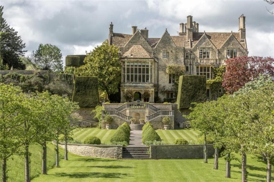 a large house with a staircase and trees in front of it