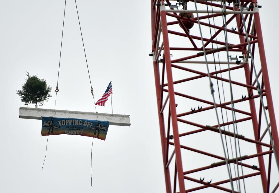 The UMass Chan Medical School ceremonial final steel beam is hoisted during a topping off ceremony for the school's research facility Monday.