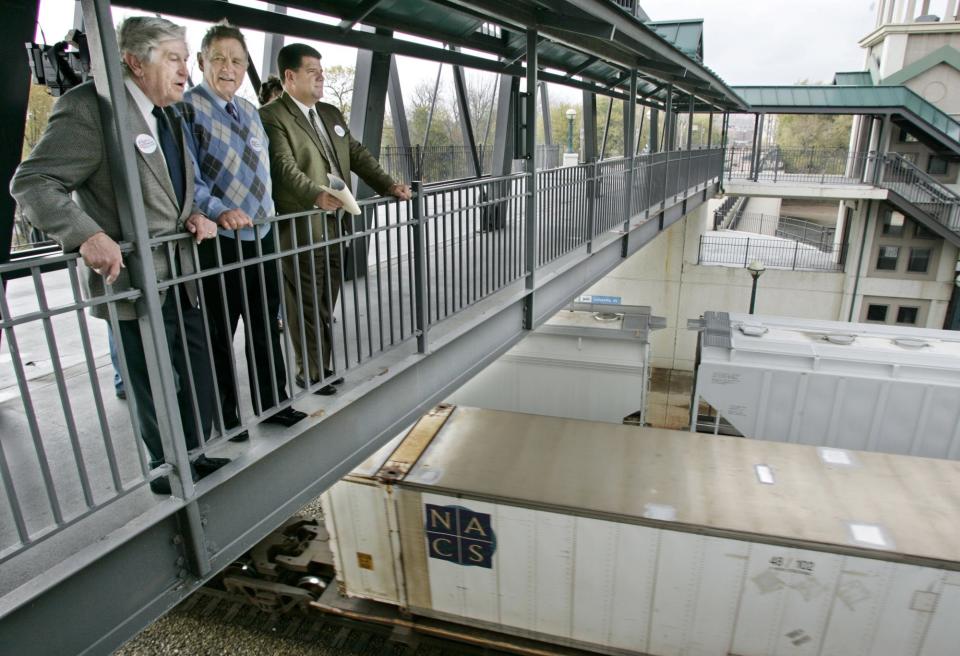 Former U.S. Sen. Birch Bayh, center, was joined by former Lafayette Mayor Jim Riehle, left, and current Mayor Tony Roswarski as they watched trains pass by Riehle Plaza on Friday, October 29, 2004. Bayh and Riehle were instrumental implementing the Railroad Relocation Project in Lafayette.