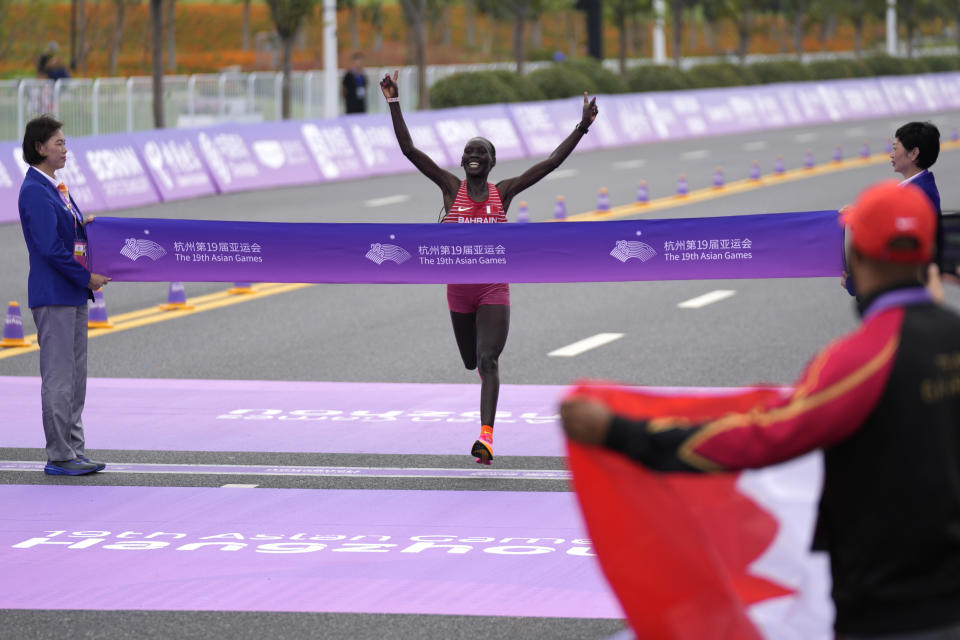 Bahrain's Eunice Chebichii Paul Chumba celebrates as she approaches the finish line to win the women's marathon at the 19th Asian Games in Hangzhou, China, Thursday, Oct. 5, 2023. (AP Photo/Aijaz Rahi)