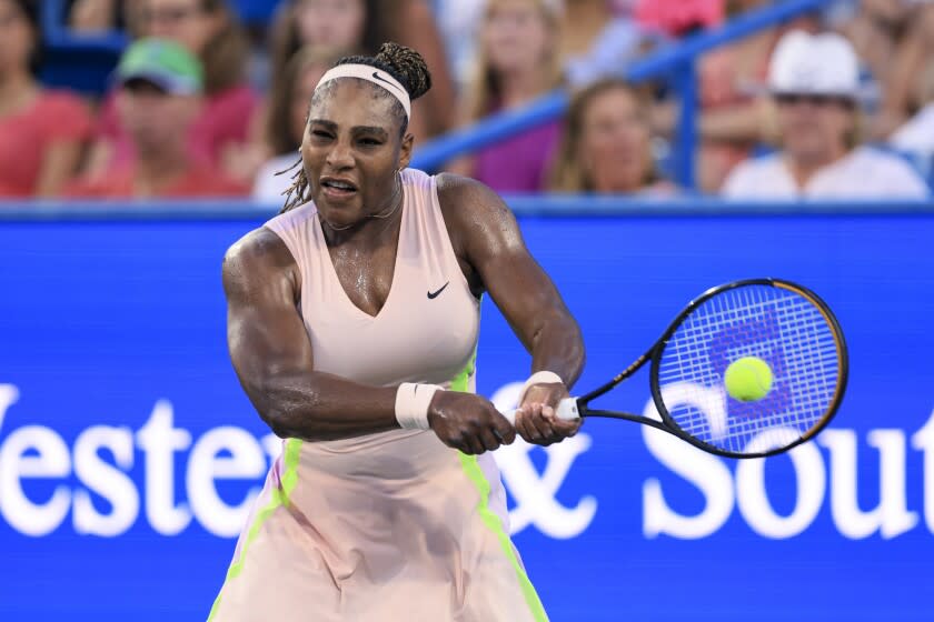 Serena Williams, of the United States, hits a backhand to Emma Raducanu, of Britain.