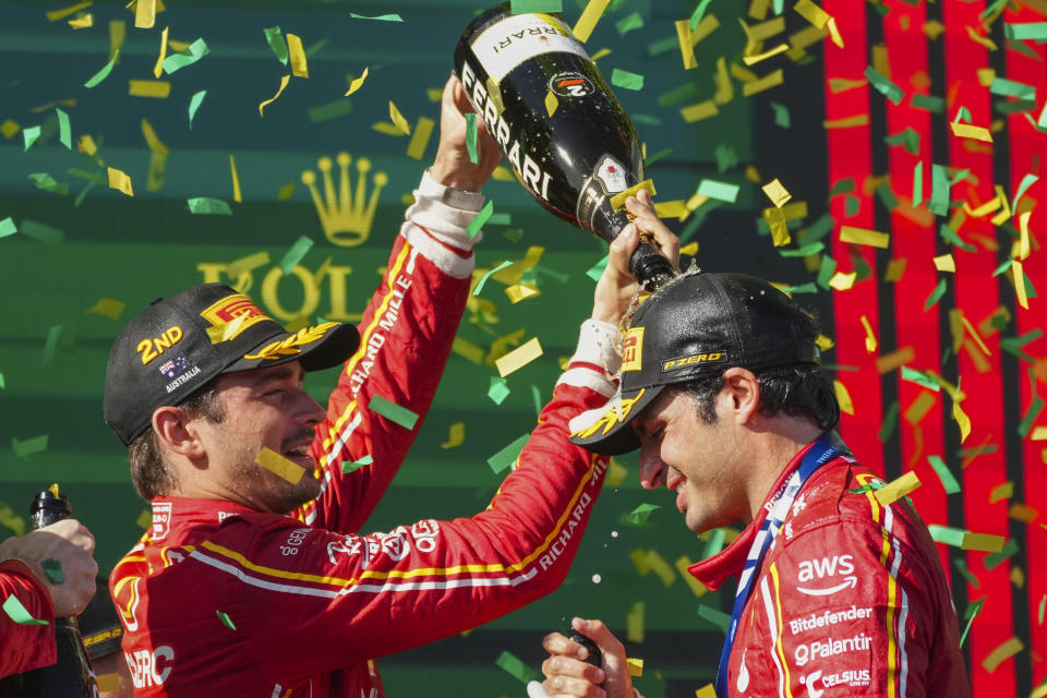 Second placed Ferrari driver Charles Leclerc, left, of Monaco pours champagne on teammate Carlos Sainz of Spain after his win at the Australian Formula One Grand Prix at Albert Park, in Melbourne, Australia, Sunday, March 24, 2024. (AP Photo/Scott Barbour)