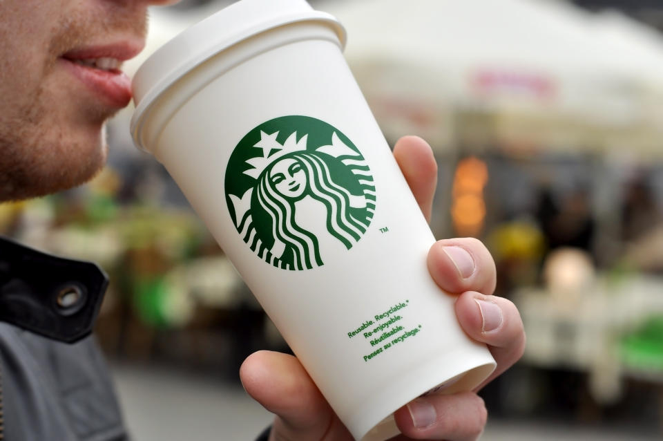 Warsaw, Poland - April 8, 2016:  An Unidentified man holding a cup of beverage from Starbucks cafe in Warsaw 