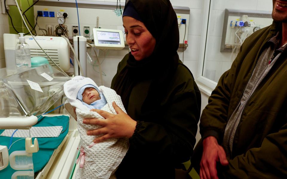 A Palestinian mother holds her newborn Anas Sbeta, who was placed in an incubator after being evacuated from Al Shifa Hospital in Gaza City