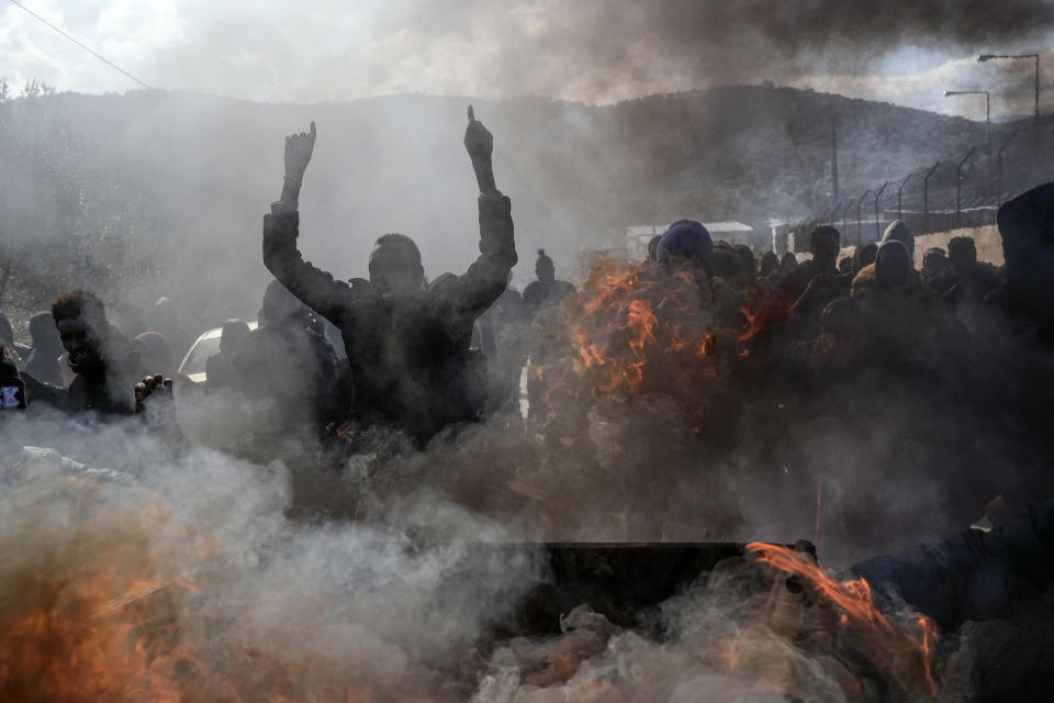 Refugees and migrants burn garbage bins and chant slogans as they demonstate outside Moria camp, following the stabbing death of an 20-year-old man from Yemen in the Greek island of Lesbos, Friday, Jan, 17, 2020. Authorities arrested a 27-year-old Afghan migrant in connection with the incident. Overcrowding at Moria has steadily worsened over the past year as the number of arrivals of migrants and refugees using clandestine routes from Turkey to the Greek islands remains high _ and totaled nearly 60,000 in 2019. (AP Photo/Aggelos Barai)