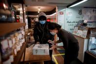 A delivery driver picks up a cake at a cafe of the French bakery Comptoirs de France in Beijing as the country is hit by an outbreak of the novel coronavirus