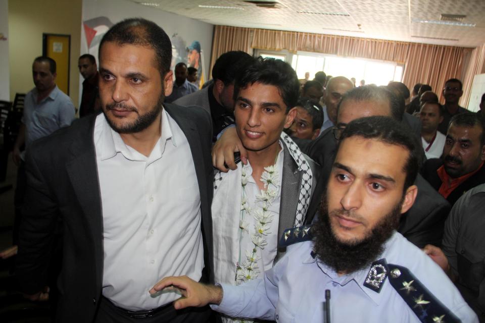 Arab Idol winner Palestinian Mohammed Assaf, center, arrives to the Rafah crossing point on the border between Egypt and southern Gaza Strip, Tuesday, June 25, 2013. Huge crowds of Gazans gave a gleeful welcome Tuesday to the first Palestinian winner of the Arab Idol talent contest, thronging the territory's border crossing with Egypt and the singer's home in hopes of embracing him, but internal politics surfaced quickly. Assaf’s victory in the popular contest Saturday sparked huge celebrations in the West Bank and Gaza, giving Palestinians a sense of pride. (AP Photo/Khaled Omar, Pool)