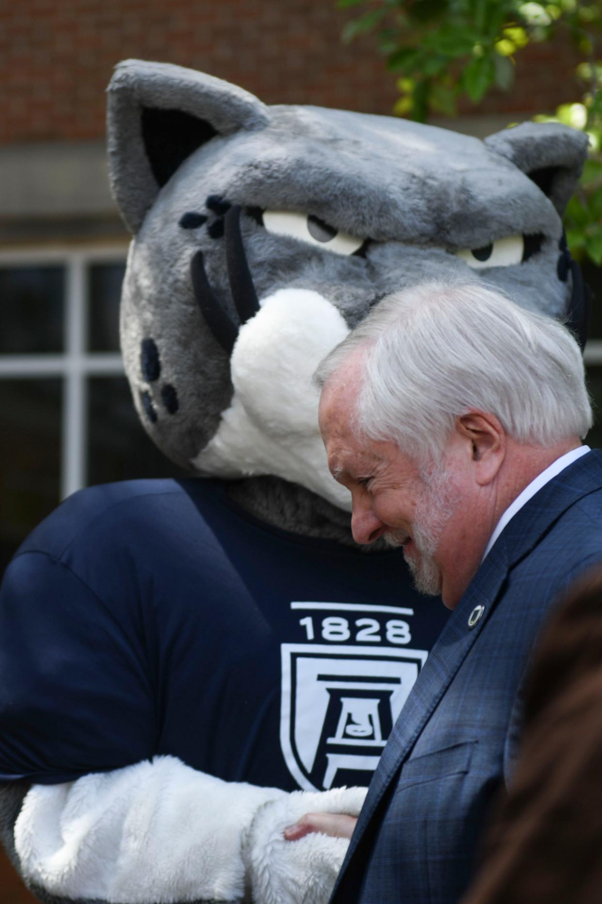 FILE - Augusta University President Brooks Keel shakes hands with Augustus the Jaguar on Tuesday, Sept. 19, 2023. On Thursday, the University System of Georgia announced the search committee to find a new president for AU after Keel announced his retirement at the end of this year.
