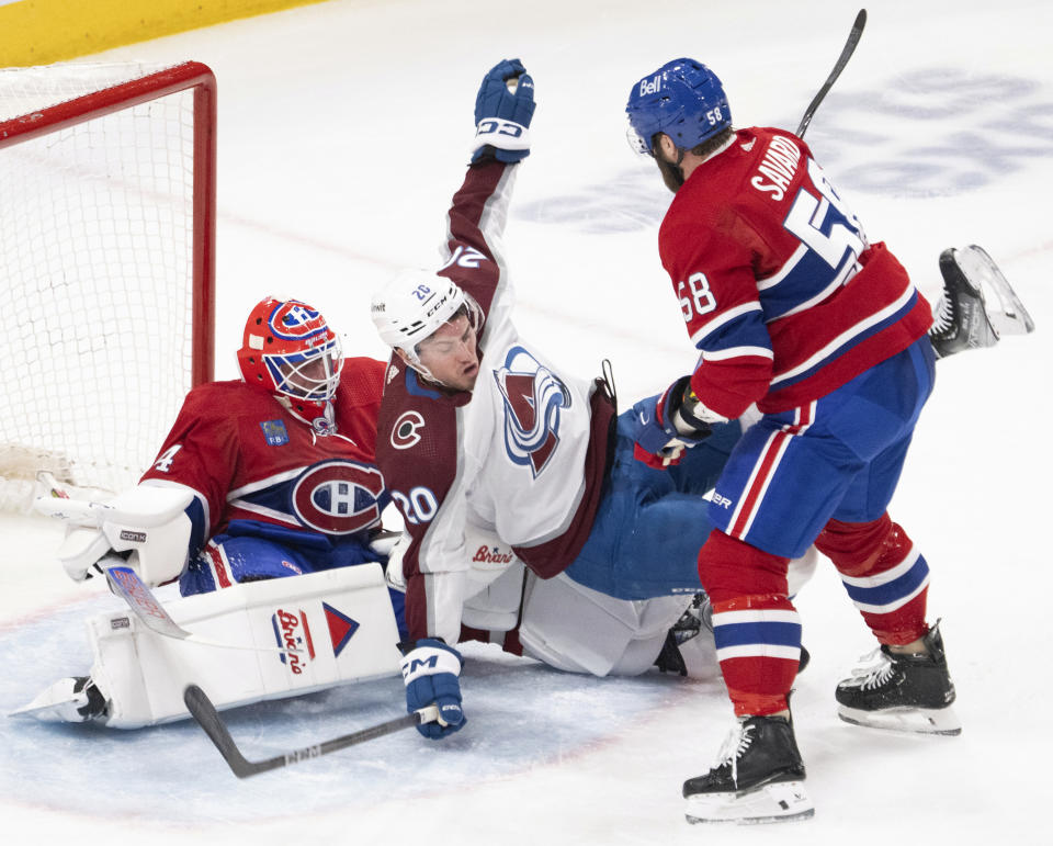 Colorado Avalanche center Ross Colton (20) is checked into Montreal Canadiens goaltender Jake Allen, left, by Canadiens defenseman David Savard (58) during second-period NHL hockey game action Monday, Jan. 15, 2024, in Montreal. (Ryan Remiorz/The Canadian Press via AP)