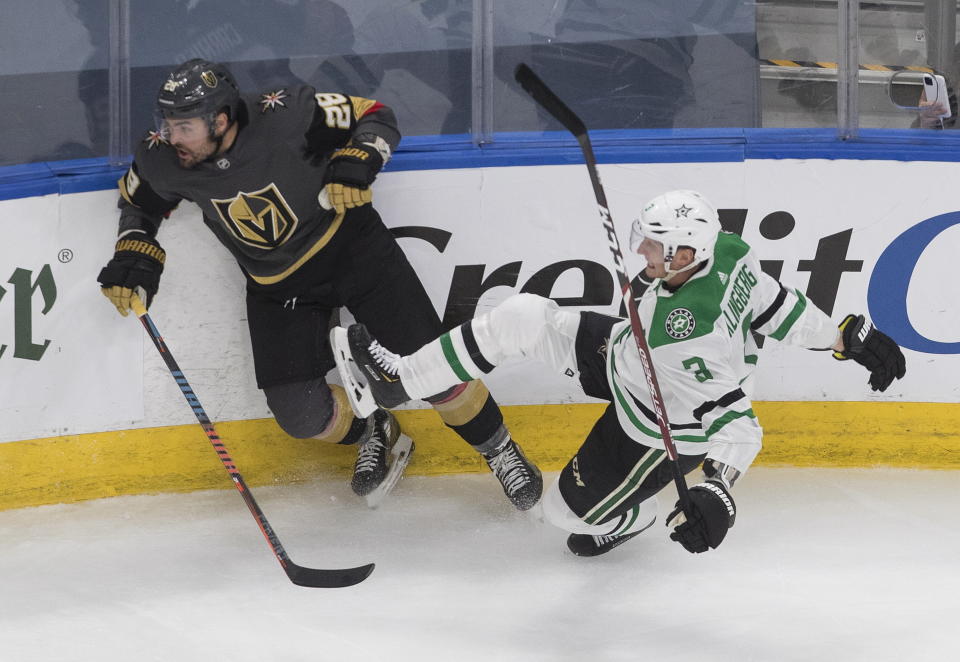 Dallas Stars' John Klingberg (3) is checked by Vegas Golden Knights' William Carrier (28) during the third period of an NHL hockey playoff game Monday, Aug. 3, 2020, in Edmonton, Alberta. (Jason Franson/The Canadian Press via AP)