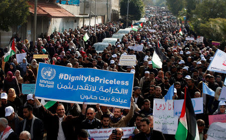 Palestinian employee of United Nations Relief and Works Agency (UNRWA) hold a sign during a protest against a U.S. decision to cut aid, in Gaza City January 29, 2018. REUTERS/Mohammed Salem