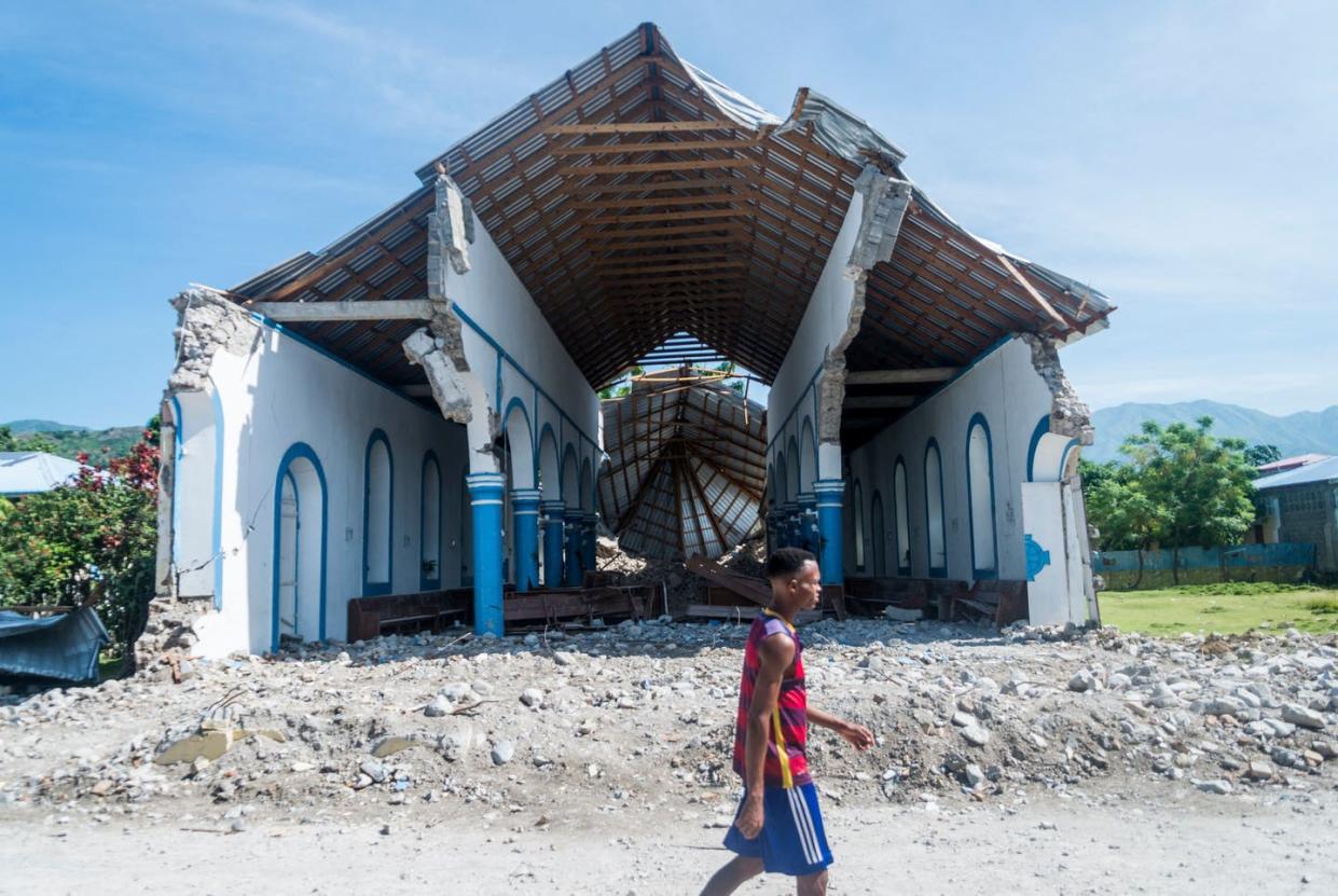 <span class="caption">Natural disasters are not uncommon in Haiti; neither is political instability.</span> <span class="attribution"><a class="link " href="https://www.gettyimages.com/detail/news-photo/man-walks-past-a-church-destroyed-during-an-earthquake-in-news-photo/1234717226?adppopup=true" rel="nofollow noopener" target="_blank" data-ylk="slk:Reginald Louissaint JR/AFP via Getty Images;elm:context_link;itc:0;sec:content-canvas">Reginald Louissaint JR/AFP via Getty Images</a></span>