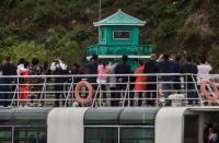 <p>Chinese tourists look and take pictures of a North Korean soldier in a watchtower as they ride on a tourist boat on the Yalu river with North Korean territory on both sides, north of the border city of Dandong, Liaoning province, northern China near Sinuiju, North Korea on May 23, 2017 in Dandong, China. (Photo: Kevin Frayer/Getty Images) </p>