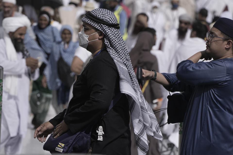 Pilgrims carry their bags outside the Grand Mosque, during the annual hajj pilgrimage, in Mecca, Saudi Arabia, Saturday, June 24, 2023. Muslim pilgrims are converging on Saudi Arabia's holy city of Mecca for the largest hajj since the coronavirus pandemic severely curtailed access to one of Islam's five pillars. (AP Photo/Amr Nabil)