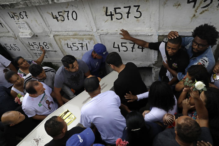 An uncle of the late 8-year-old Ágatha Sales Felix, second from right, shouts and cries during her burial at the cemetery in Rio de Janeiro, Brazil, Sunday, Sept. 22, 2019. Félix was hit by a stray bullet Friday amid what police said was shootout with suspected criminals. However, residents say there was no shootout, and blame police. (AP Photo/Silvia Izquierdo)