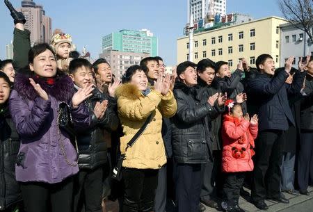 North Koreans watching a huge screen broadcasting an official announcement that the country "successfully" put an Earth observation satellite into orbit, calling it an "epoch-making" achievement, applaud in Pyongyang, North Korea, in this photo released by Kyodo February 7, 2016. REUTERS/Kyodo