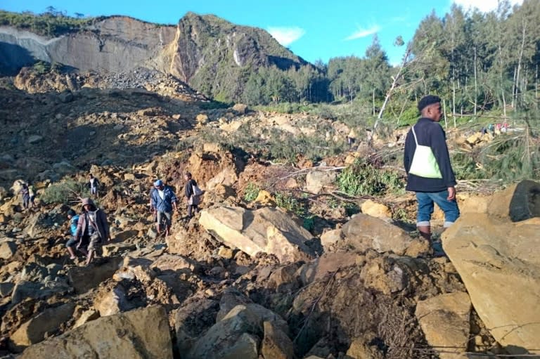 People gather at the site of a massive landslide in Papua New Guinea's Enga province on Friday (STR)
