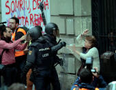 A woman is grabbed by riot police near a a polling station for the banned independence referendum in Barcelona. REUTERS/Enrique Calvo