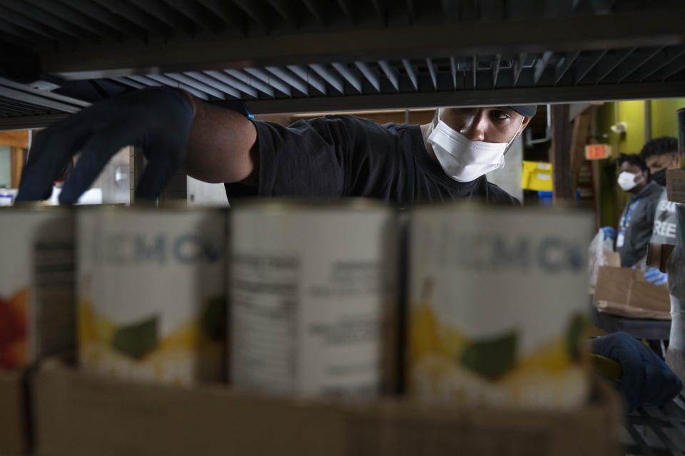 Allen Stewart, 26, a Food and Rescue Coordinator at Bread for the City adds food items to the food pantry, Wednesday, May 10, 2023, in Washington. The formal end of the national Public Health Emergency on Thursday marks the end of several U.S. pandemic-era emergency support program, from extra food assistance to automatic enrollment in Medicaid. (AP Photo/Jacquelyn Martin)