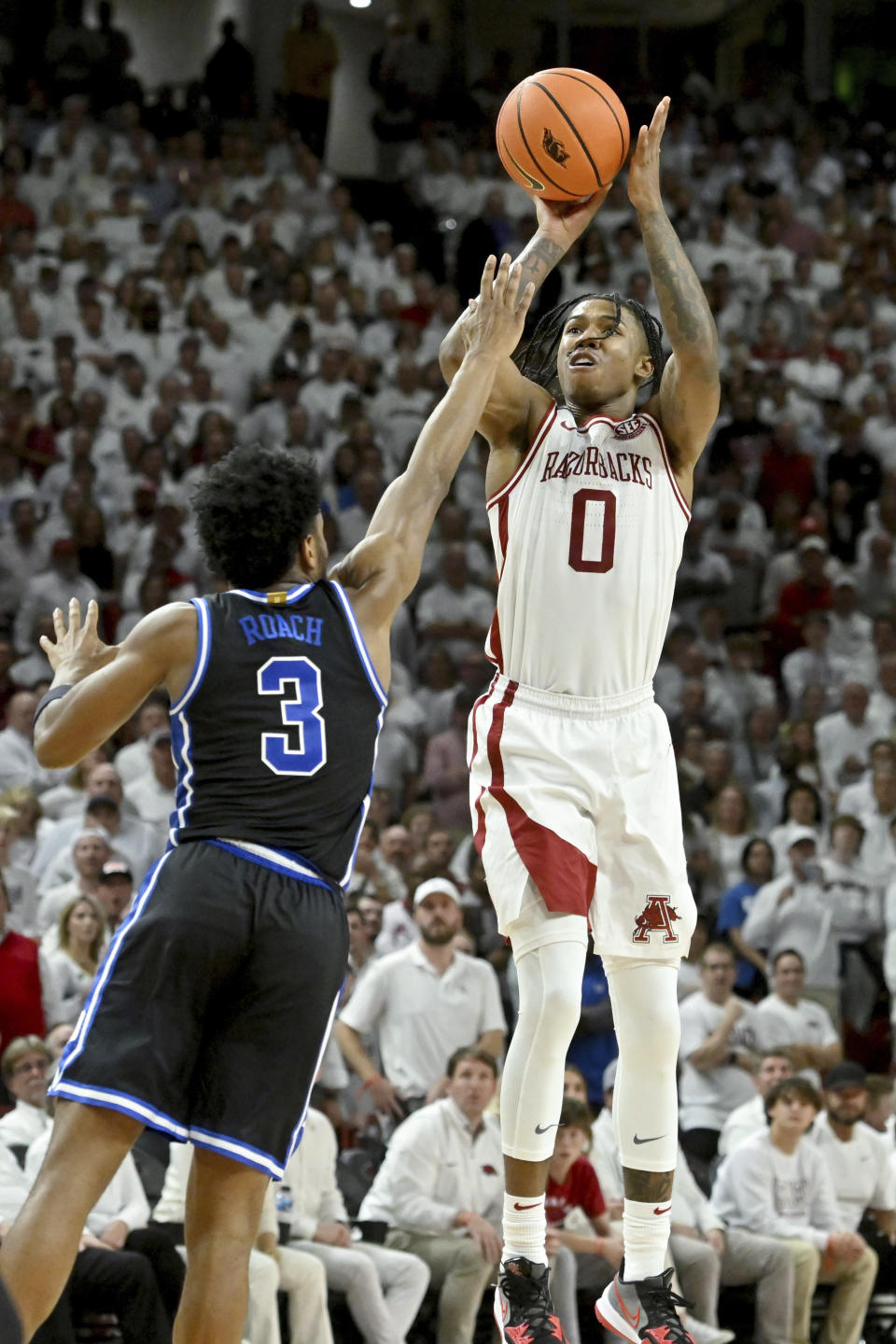 Arkansas guard Khalif Battle (0) is fouled by Duke guard Jeremy Roach (3) as he shoots a three-point shot during the second half of an NCAA college basketball game Wednesday, Nov. 29, 2023, in Fayetteville, Ark. (AP Photo/Michael Woods)