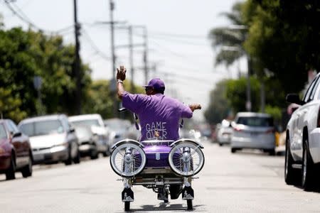 William Holloway rides his customized Los Angeles Lakers inspired low rider bicycle outside Manny's bike shop in Compton, California U.S., June 3, 2016. Picture taken June 3, 2016. REUTERS/Mario Anzuoni