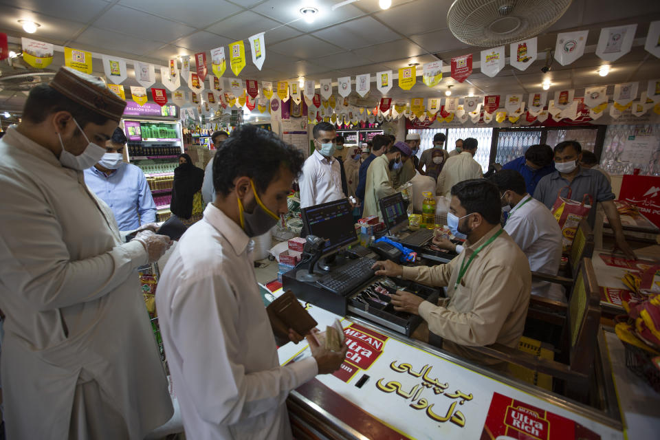 People buy groceries ahead of lockdown to help to contain the spread of coronavirus, in Islamabad, Pakistan, Friday, June 12, 2020. Capital administration is planning to seal few areas of Islamabad following the decision taken on the advice of the Health Department and epidemiologists after hundreds of cases were reported from these areas. (AP Photo/B.K. Bangash)