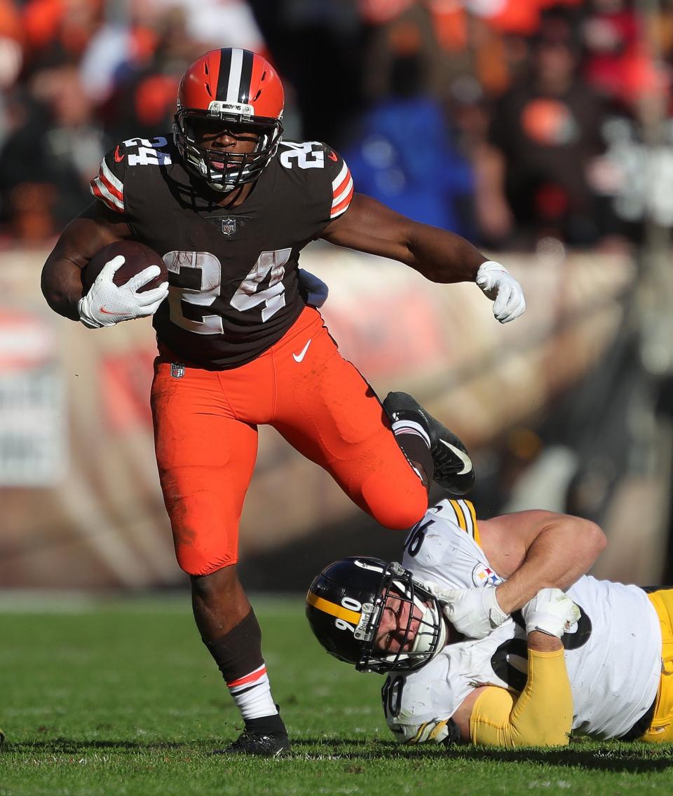 Cleveland Browns running back Nick Chubb (24) escapes Pittsburgh Steelers outside linebacker T.J. Watt (90) as he rushes for yards during the second half of an NFL football game, Sunday, Oct. 31, 2021, in Cleveland, Ohio. [Jeff Lange/Beacon Journal]