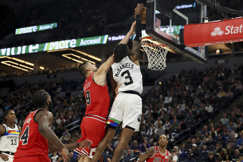 Minnesota Timberwolves forward Jaden McDaniels (3) goes up to the basket against Chicago Bulls center Nikola Vucevic (9) during the second half of an NBA basketball game Sunday, Dec. 18, 2022, in Minneapolis. (AP Photo/Stacy Bengs)