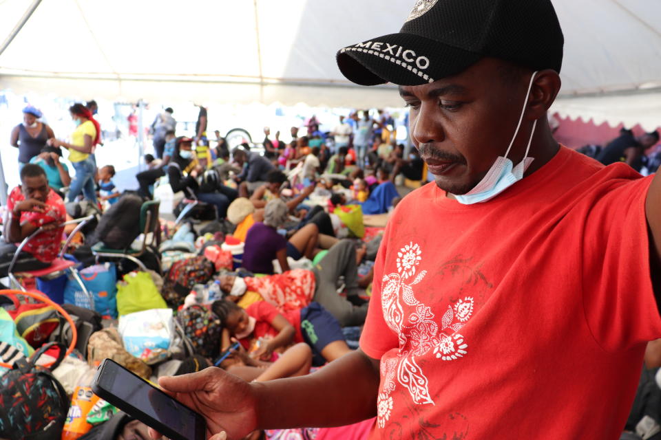 Selomourd Menrrivil, from Cap-Haitien, Haiti, looks at his cell phone as he gathers with other migrants in Monterrey, Mexico, Thursday, Sept. 23, 2021. Menrrivil, 43, continued receiving daily updates all week from other Haitians in Del Rio and Ciudad Acuña, after arriving with his wife and two teen daughters, and has decided to legalize his status in Mexico. (AP Photo/Marcos Martinez Chacon)