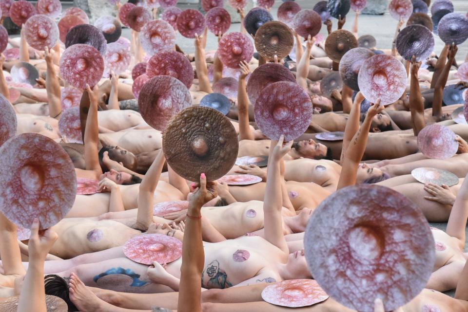 People pose nude holding cut outs of nipples during a photo shoot by Tunick on June 2, 2019 in New York City. Tunick staged his photo shoot in front of the Facebook building in Manhattan to protest Facebook and Instagram's ban on showing the female nipple on their social media platforms. Tunic says that the ban hurts fine artists who use nudity in their artwork.