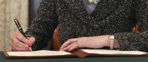 Close up of Britain's Prime Minister Theresa May as she signs the official letter to European Council President Donald Tusk, in 10 Downing Street, London, Tuesday March 28, 2017, invoking Article 50 of the bloc's key treaty, the formal start of exit negotiations. Britons voted in June to leave the bloc after four decades of membership. (Christopher Furlong/Pool Photo via AP)