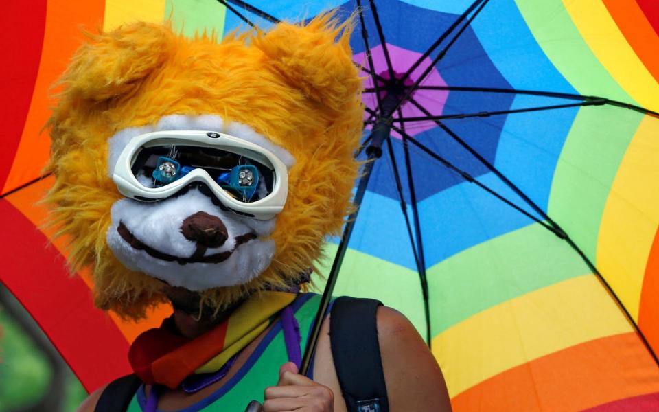 A supporter holds a rainbow umbrella during a rally ahead of Taiwan's top court ruling on same-sex marriage - Credit: TYRONE SIU/ REUTERS