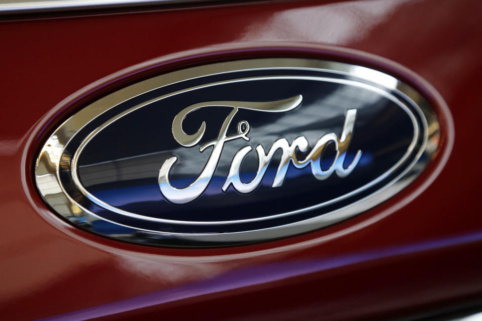 FILE- This Feb. 15, 2018, file photo shows a Ford logo on a vehicle at the Pittsburgh Auto Show in Pittsburgh. Ford and Walmart are partnering to test a self-driving grocery delivery service. Ford will work with Walmart to determine what goods it can feasibly transport and figure out what issues may need to be addressed to successfully deliver orders via self-driving vehicles. (AP Photo/Gene J. Puskar, File)