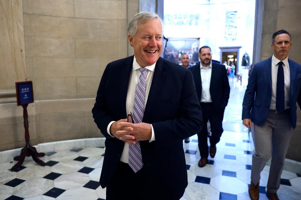 Former Trump White House Chief of Staff Mark Meadows grins and clasps his hands together while walking through the office of the Speaker of the House at the U.S. Capitol