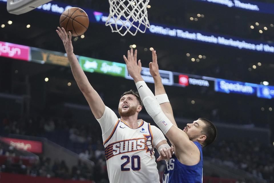 Phoenix Suns center Jusuf Nurkic, left, shoots as Los Angeles Clippers center Ivica Zubac defends during the first half of an NBA basketball game Monday, Jan. 8, 2024, in Los Angeles. (AP Photo/Mark J. Terrill)