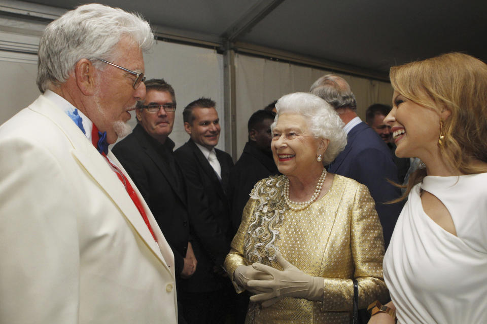 FILE - Queen Elizabeth II meets Rolf Harris, left, and Kylie Minogue, right, backstage at The Diamond Jubilee Concert in London, Monday June 4, 2012. Rolf Harris, the veteran entertainer whose decades-long career as a family favorite on British and Australian television was shattered when he was convicted of sexual assaults on young girls, has died. He was 93. (AP Photo /Dave Thompson, Pool, File)